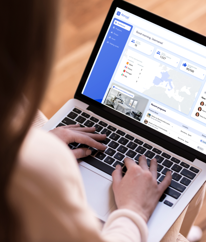 Usuario navegando en una plataforma de análisis de datos con interfaz azul en laptop, mostrando dashboard con estadísticas, mapa de Europa y propiedades inmobiliarias - herramienta digital para gestión de propiedades